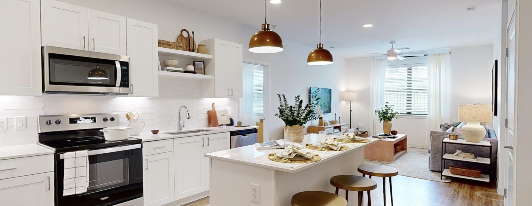 Kitchen with white cabinets island and hanging lights at Citizen House Blue Bluff pet-friendly apartments in Austin.
